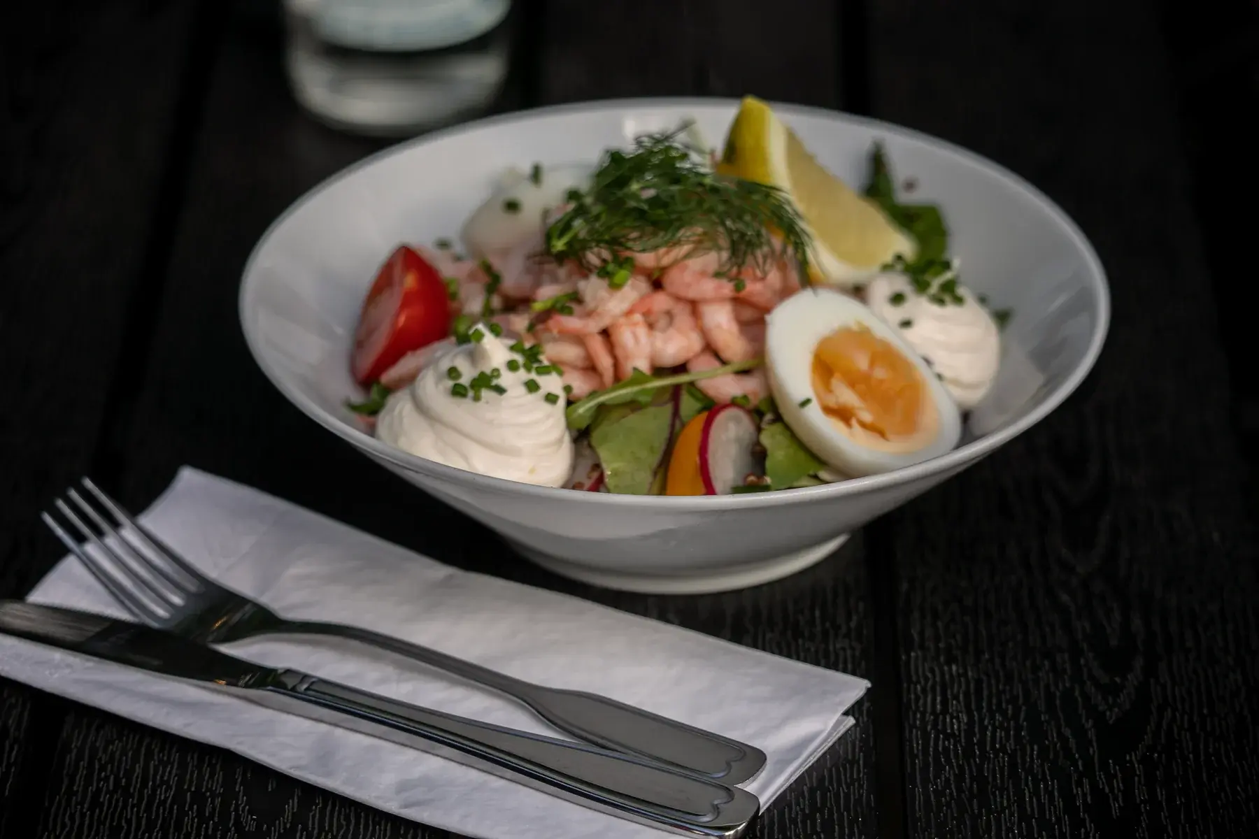 Prawn salad with egg and lemon on a laid table