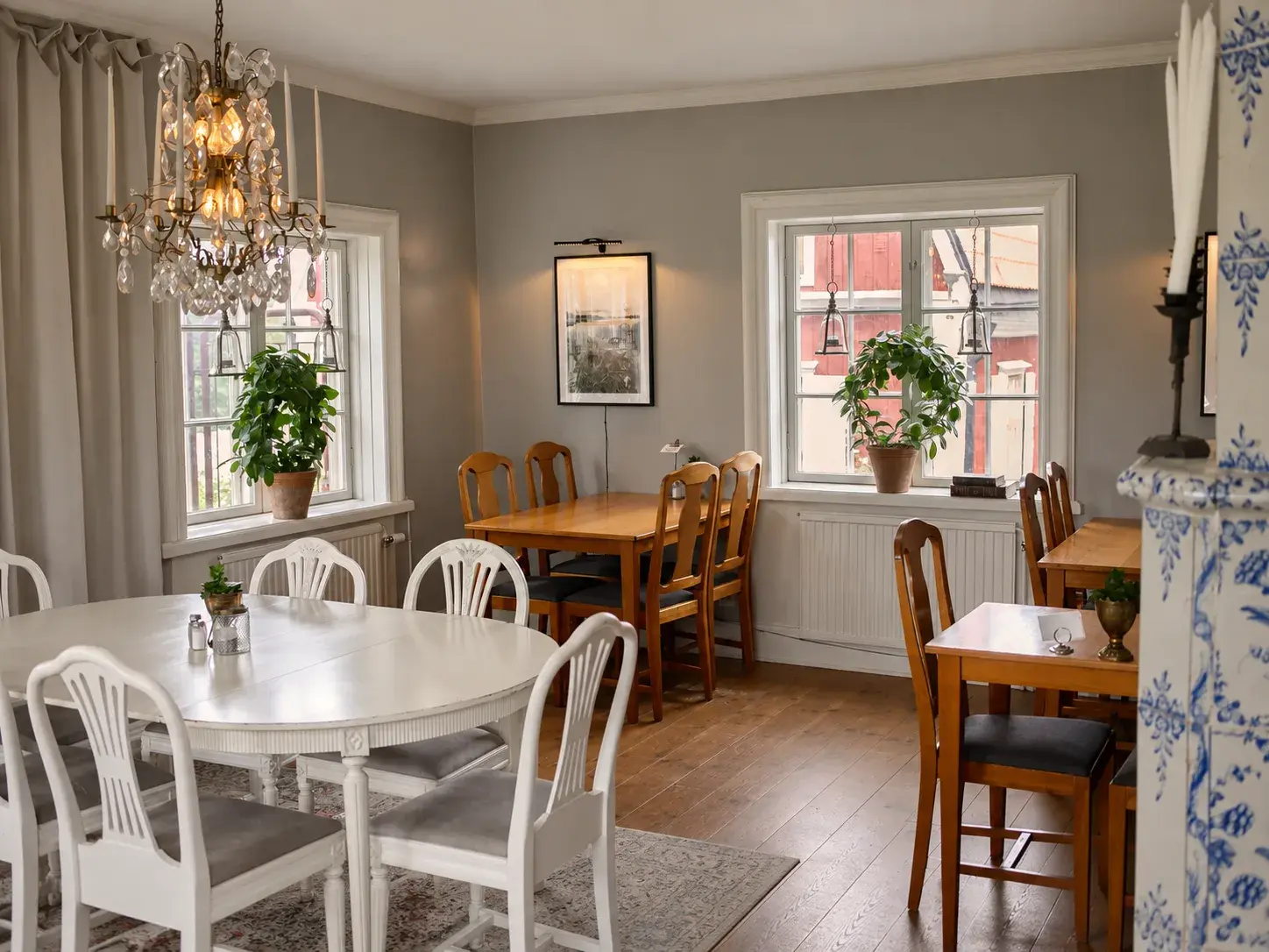 The downstairs dining room with a crystal chandelier and a blue-and-white tiled stove
